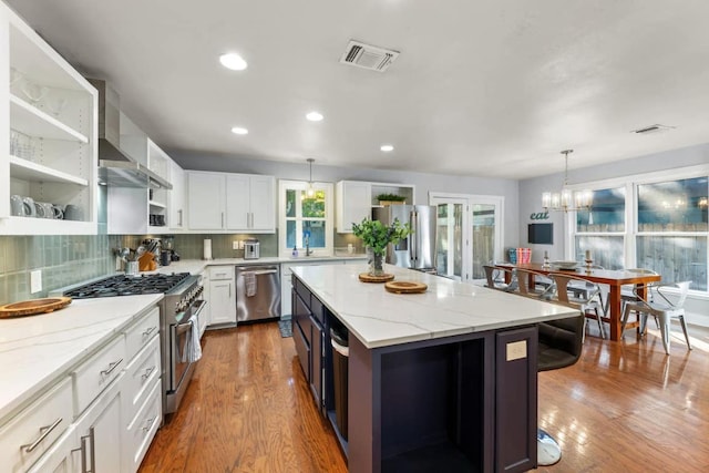 611 W Johanna St, Austin, TX 78704 - kitchen with open shelves, appliances with stainless steel finishes, wood finished floors, white cabinetry, and recessed lighting