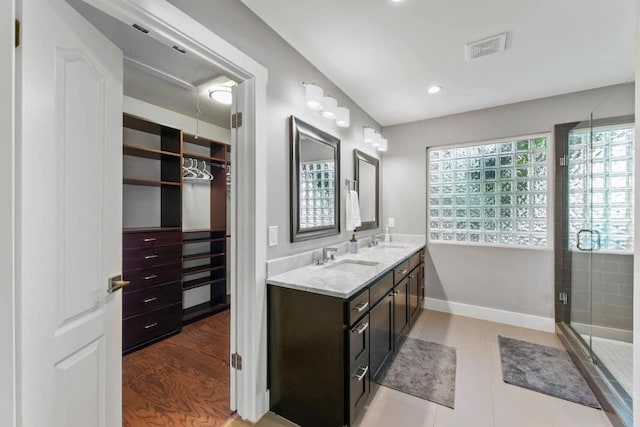 611 W Johanna St, Austin, TX 78704 - full bath with double vanity, a walk in closet, a shower stall, and recessed lighting