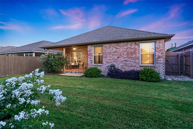 18708 Moreto Loop, Pflugerville, TX 78660 - rear view of property featuring a fenced backyard, roof with shingles, and brick siding