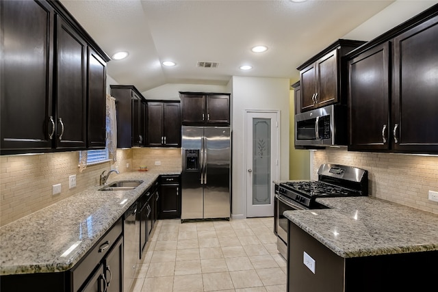 18708 Moreto Loop, Pflugerville, TX 78660 - kitchen featuring appliances with stainless steel finishes, light stone countertops, decorative backsplash, light tile patterned flooring, and vaulted ceiling