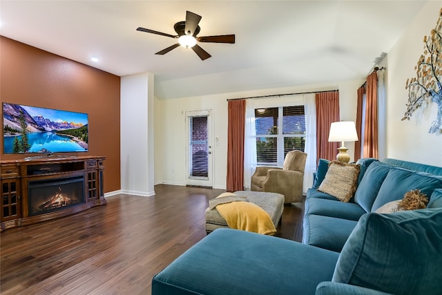 18708 Moreto Loop, Pflugerville, TX 78660 - living room featuring dark wood-style floors, ceiling fan, and a lit fireplace
