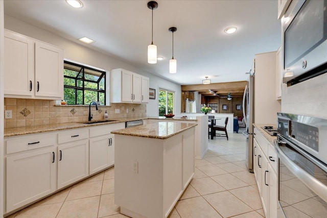 9410 Topridge Dr, Austin, TX 78750 - kitchen featuring appliances with stainless steel finishes, a peninsula, decorative backsplash, light tile patterned flooring, and recessed lighting