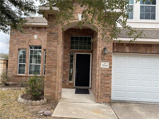 2700 Saddle Blanket Pl, Leander, TX 78641 - entrance to property featuring brick siding, a garage, and a shingled roof