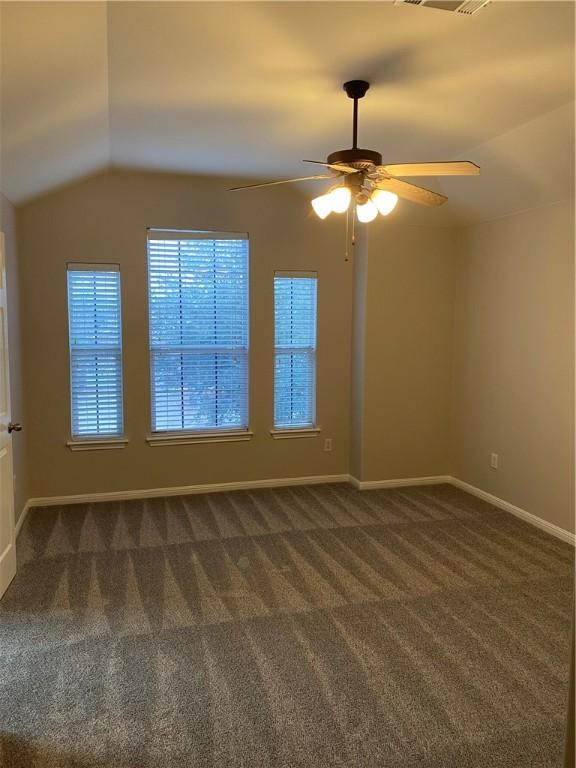2700 Saddle Blanket Pl, Leander, TX 78641 - empty room featuring a ceiling fan, dark carpet, and vaulted ceiling