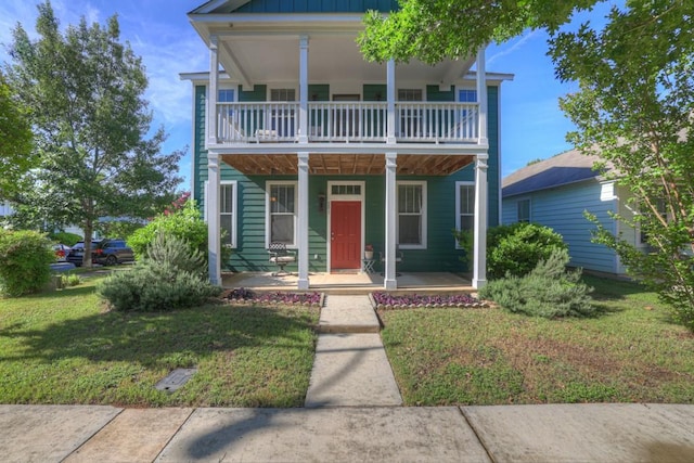 201 Trestle Tree, San Marcos, TX 78666 - view of front of property featuring a porch, a balcony, a front lawn, and board and batten siding