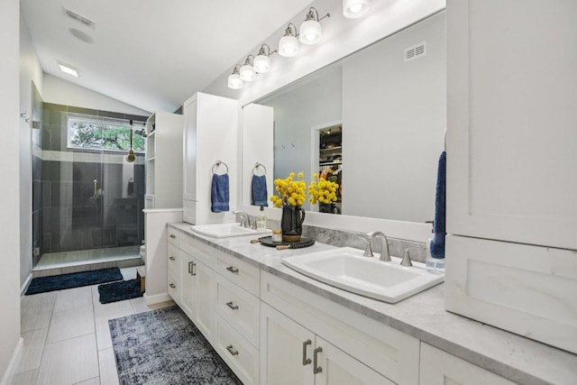 9100 Bill Hickcock Pass, Austin, TX 78748 - full bathroom with double vanity, a shower stall, lofted ceiling, tile patterned floors, and a spacious closet