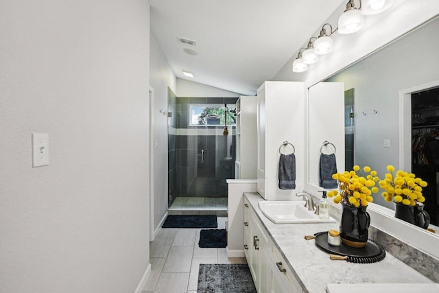 9100 Bill Hickcock Pass, Austin, TX 78748 - bathroom featuring a shower stall, vaulted ceiling, double vanity, and a walk in closet