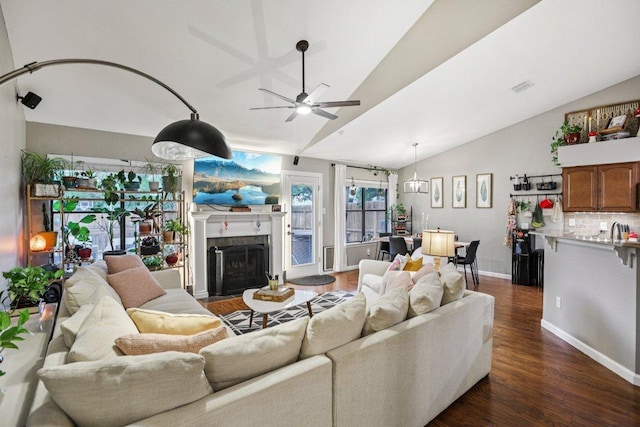 9100 Bill Hickcock Pass, Austin, TX 78748 - living area featuring vaulted ceiling, ceiling fan, dark wood-style flooring, and a fireplace with flush hearth