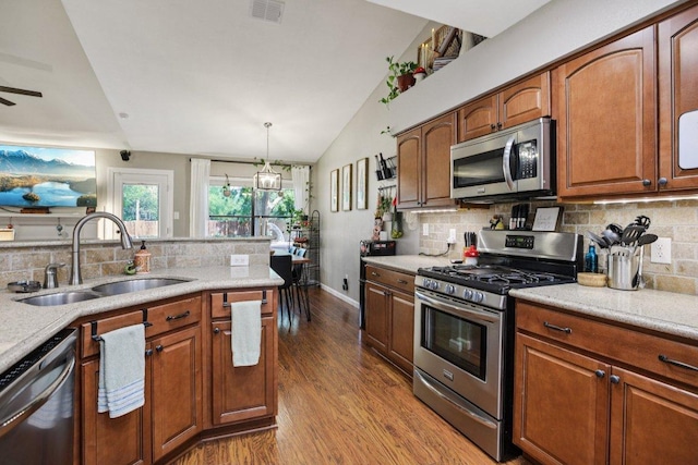 9100 Bill Hickcock Pass, Austin, TX 78748 - kitchen with stainless steel appliances, decorative backsplash, vaulted ceiling, and light countertops