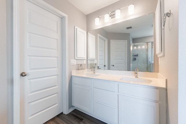 1805 Bogata Ln, Leander, TX 78641 - bathroom with a stall shower, double vanity, and wood finished floors