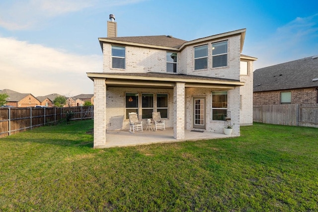 1805 Bogata Ln, Leander, TX 78641 - rear view of house featuring a fenced backyard, brick siding, a chimney, and a patio