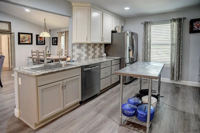 569 Mcallister Rd, Bastrop, TX 78602 - kitchen featuring stainless steel appliances, decorative backsplash, light wood-style floors, vaulted ceiling, and light stone counters