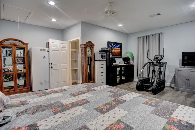 569 Mcallister Rd, Bastrop, TX 78602 - bedroom featuring attic access, freestanding refrigerator, wood finished floors, and recessed lighting