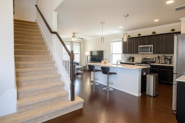 16021 Remington Reserve Way, Austin, TX 78728 - kitchen with appliances with stainless steel finishes, light countertops, a kitchen breakfast bar, dark wood finished floors, and backsplash