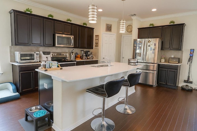 16021 Remington Reserve Way, Austin, TX 78728 - kitchen featuring stainless steel appliances, decorative backsplash, dark brown cabinets, a breakfast bar area, and dark wood finished floors
