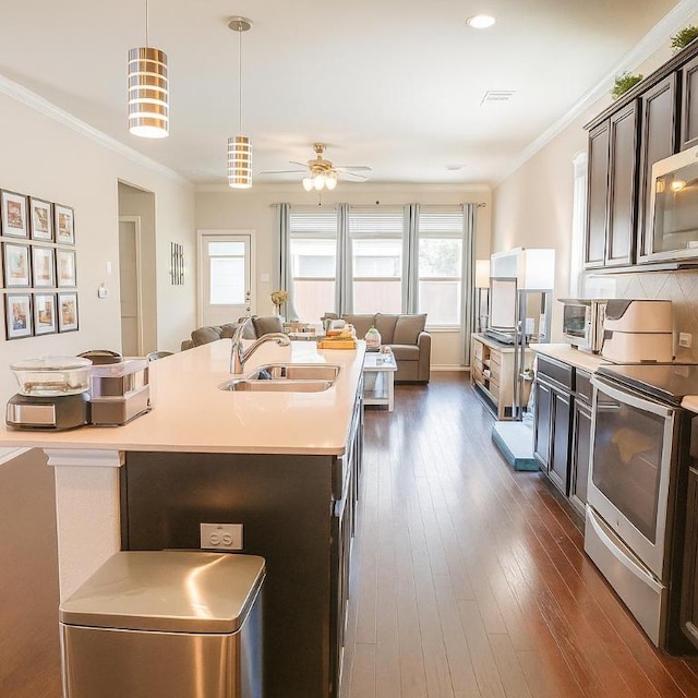 16021 Remington Reserve Way, Austin, TX 78728 - kitchen featuring stainless steel appliances, open floor plan, light countertops, ceiling fan, and dark brown cabinetry