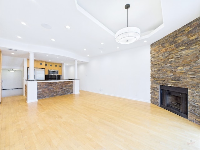 1501 Barton Springs Rd Unit 222, Austin, TX 78704 - unfurnished living room with light wood finished floors, a stone fireplace, recessed lighting, and ornate columns