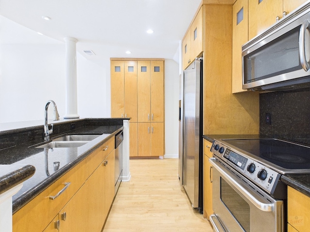 1501 Barton Springs Rd Unit 222, Austin, TX 78704 - kitchen with stainless steel appliances, dark stone countertops, light wood finished floors, recessed lighting, and glass insert cabinets