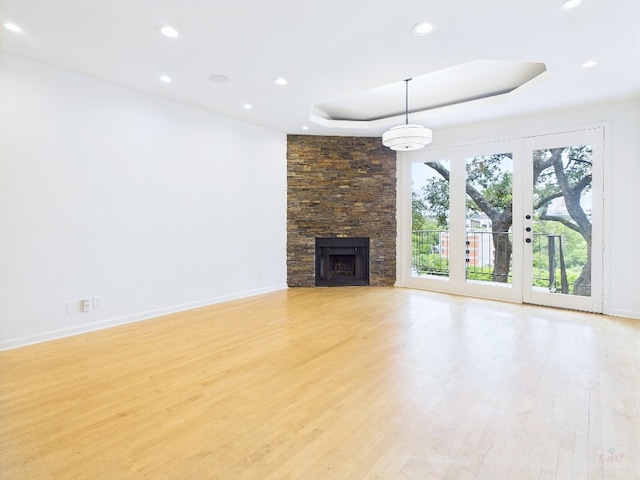 1501 Barton Springs Rd Unit 222, Austin, TX 78704 - unfurnished living room featuring a tray ceiling, recessed lighting, light wood finished floors, and a fireplace