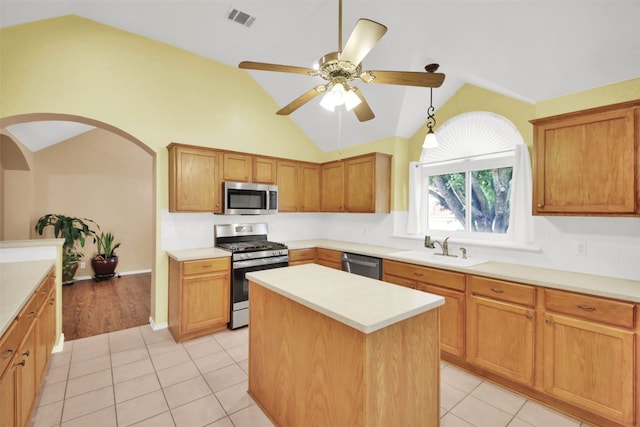 606 Dundalk Bay Cv, Pflugerville, TX 78660 - kitchen with stainless steel appliances, vaulted ceiling, a center island, a ceiling fan, and light countertops
