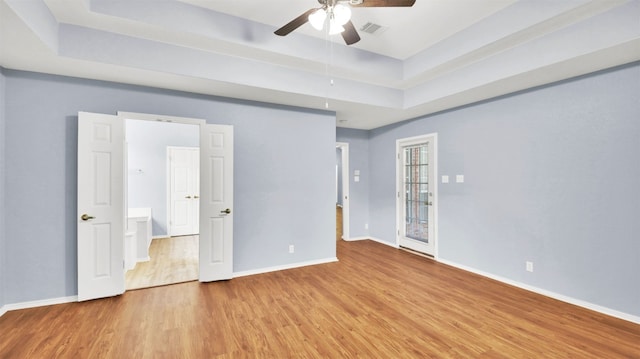 606 Dundalk Bay Cv, Pflugerville, TX 78660 - unfurnished bedroom with a raised ceiling, wood finished floors, and ceiling fan