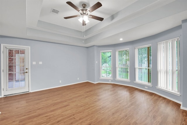 606 Dundalk Bay Cv, Pflugerville, TX 78660 - empty room with a raised ceiling, ceiling fan, and wood finished floors