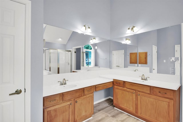 606 Dundalk Bay Cv, Pflugerville, TX 78660 - full bath with a stall shower, double vanity, wood finished floors, and vaulted ceiling