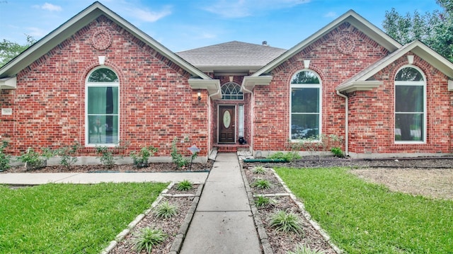 606 Dundalk Bay Cv, Pflugerville, TX 78660 - ranch-style house featuring a front yard, brick siding, and roof with shingles