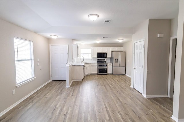 706 Brown St, Lampasas, TX 76550 - kitchen featuring appliances with stainless steel finishes, light wood-type flooring, light countertops, and white cabinetry