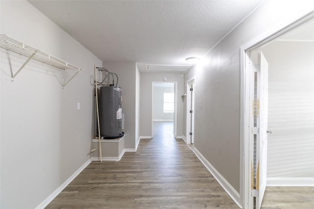 706 Brown St, Lampasas, TX 76550 - hall with electric water heater, wood finished floors, and a textured ceiling