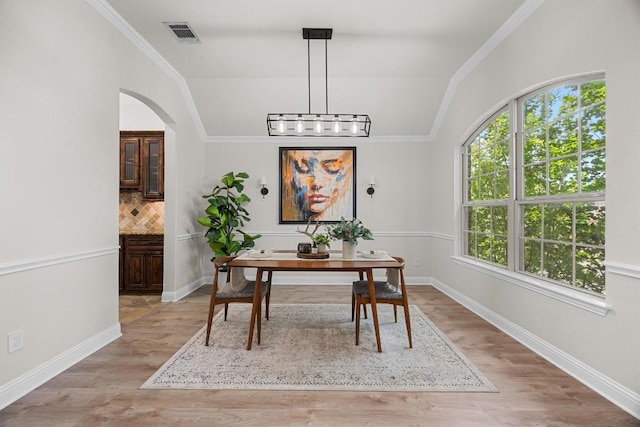 100 Crystal Cv, Round Rock, TX 78664 - dining space featuring light wood finished floors, lofted ceiling, arched walkways, and crown molding