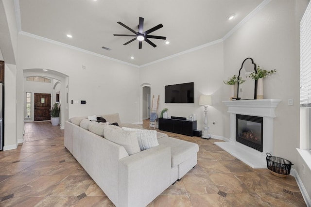 100 Crystal Cv, Round Rock, TX 78664 - living area featuring arched walkways, a ceiling fan, a glass covered fireplace, stone tile floors, and recessed lighting