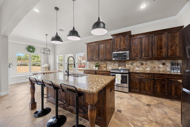 100 Crystal Cv, Round Rock, TX 78664 - kitchen with stainless steel appliances, light stone counters, decorative backsplash, a kitchen bar, and a center island with sink