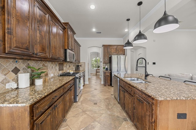 100 Crystal Cv, Round Rock, TX 78664 - kitchen featuring stainless steel appliances, arched walkways, backsplash, a kitchen island with sink, and stone counters