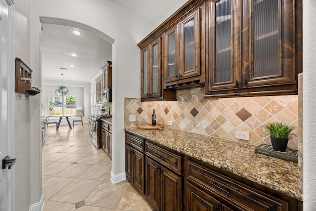100 Crystal Cv, Round Rock, TX 78664 - kitchen with arched walkways, appliances with stainless steel finishes, tasteful backsplash, dark brown cabinets, and recessed lighting
