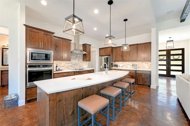 2471 George Pass, Canyon Lake, TX 78133 - kitchen with stainless steel appliances, finished concrete flooring, decorative backsplash, a kitchen island with sink, and a kitchen bar