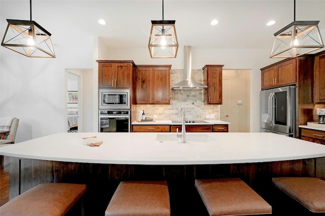 2471 George Pass, Canyon Lake, TX 78133 - kitchen with appliances with stainless steel finishes, wall chimney range hood, decorative backsplash, light countertops, and brown cabinets
