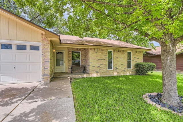 2112 Cindy Ln, Austin, TX 78727 - single story home with a front yard, an attached garage, driveway, and brick siding
