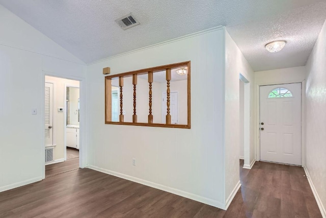 2112 Cindy Ln, Austin, TX 78727 - entrance foyer featuring a textured ceiling, dark wood-style floors, and vaulted ceiling