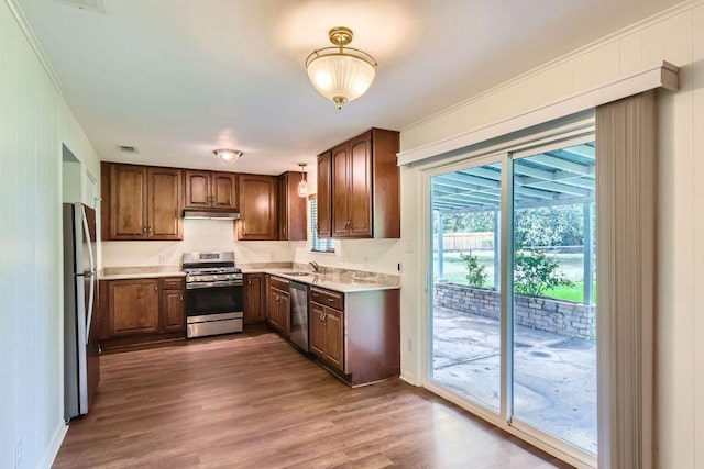 2112 Cindy Ln, Austin, TX 78727 - kitchen featuring stainless steel appliances, under cabinet range hood, wood finished floors, and light countertops