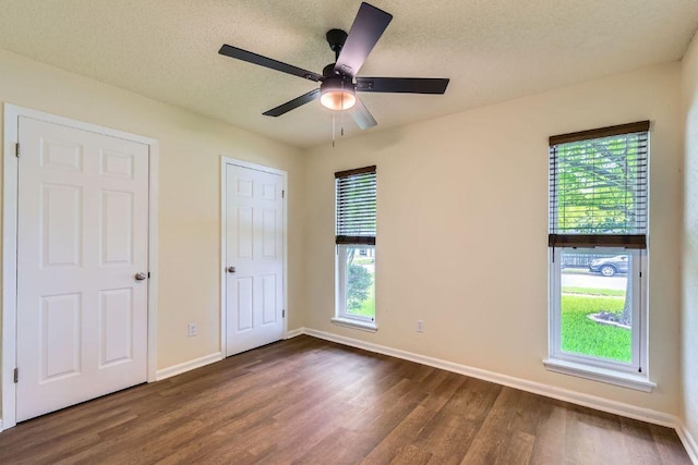 2112 Cindy Ln, Austin, TX 78727 - unfurnished bedroom with dark wood-style flooring, a textured ceiling, and a ceiling fan