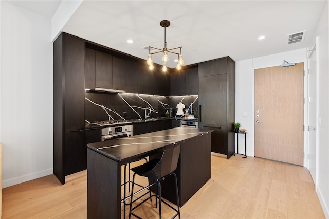 44 E Ave Unit 1404, Austin, TX 78701 - kitchen featuring dark countertops, light wood finished floors, modern cabinets, tasteful backsplash, and wall oven