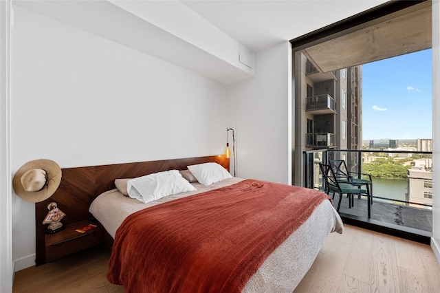 44 E Ave Unit 1404, Austin, TX 78701 - bedroom with a wall of windows, wood finished floors, and access to exterior