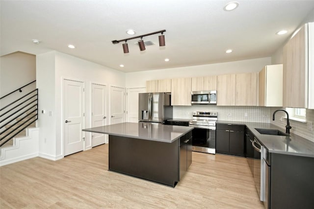 7601 Cooper Ln Unit 25, Austin, TX 78745 - kitchen with appliances with stainless steel finishes, a kitchen island, light wood-style flooring, light brown cabinets, and recessed lighting