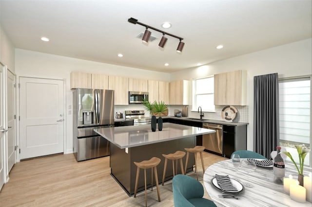 7601 Cooper Ln Unit 25, Austin, TX 78745 - kitchen featuring stainless steel appliances, light brown cabinetry, a center island, a kitchen bar, and recessed lighting