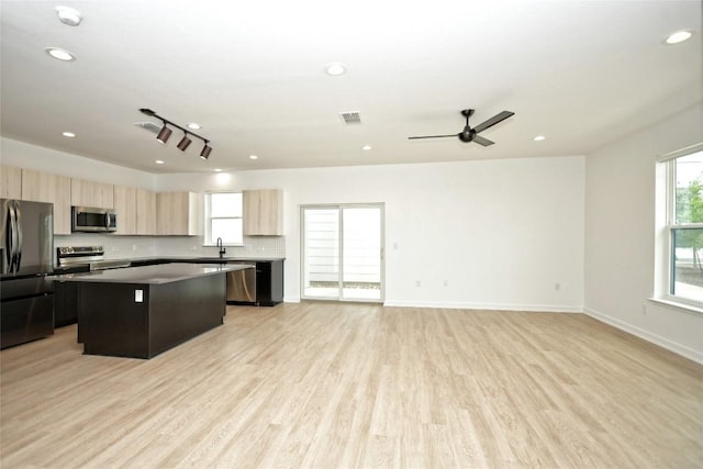7601 Cooper Ln Unit 25, Austin, TX 78745 - kitchen with appliances with stainless steel finishes, a center island, light brown cabinets, light wood-type flooring, and open floor plan