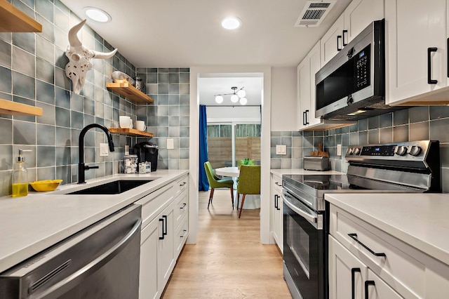 1206 Hollow Creek Dr Unit 3, Austin, TX 78704 - kitchen with appliances with stainless steel finishes, open shelves, tasteful backsplash, light countertops, and recessed lighting