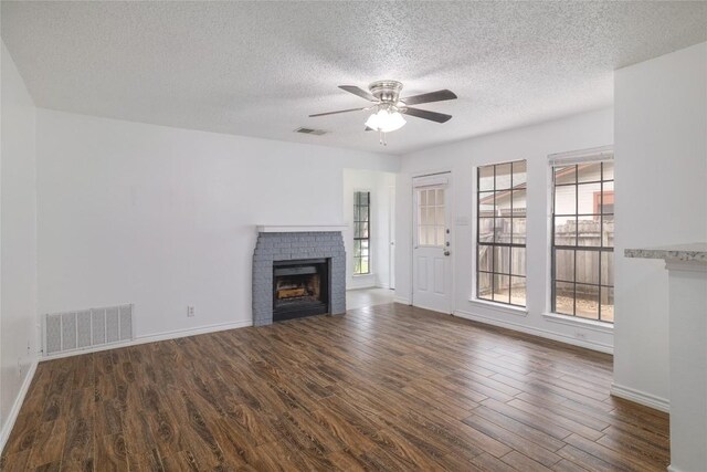 9206 Kempler Dr, Austin, TX 78748 - unfurnished living room with a fireplace, wood finished floors, a textured ceiling, and a ceiling fan