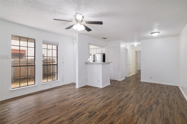 9206 Kempler Dr, Austin, TX 78748 - unfurnished living room with dark wood-style flooring, a textured ceiling, and a ceiling fan