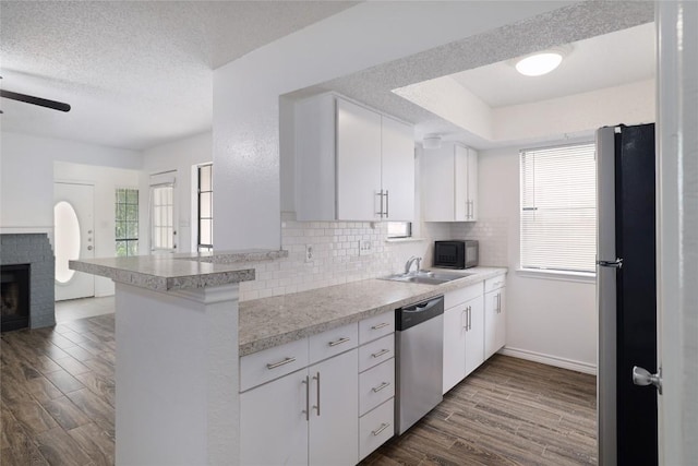 9206 Kempler Dr, Austin, TX 78748 - kitchen featuring stainless steel appliances, tasteful backsplash, dark wood finished floors, light countertops, and a textured ceiling